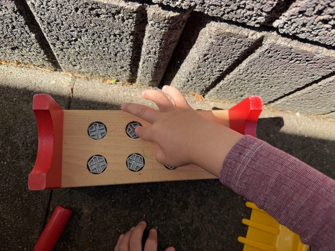 Kinderhand erkundet Holzspielzeug